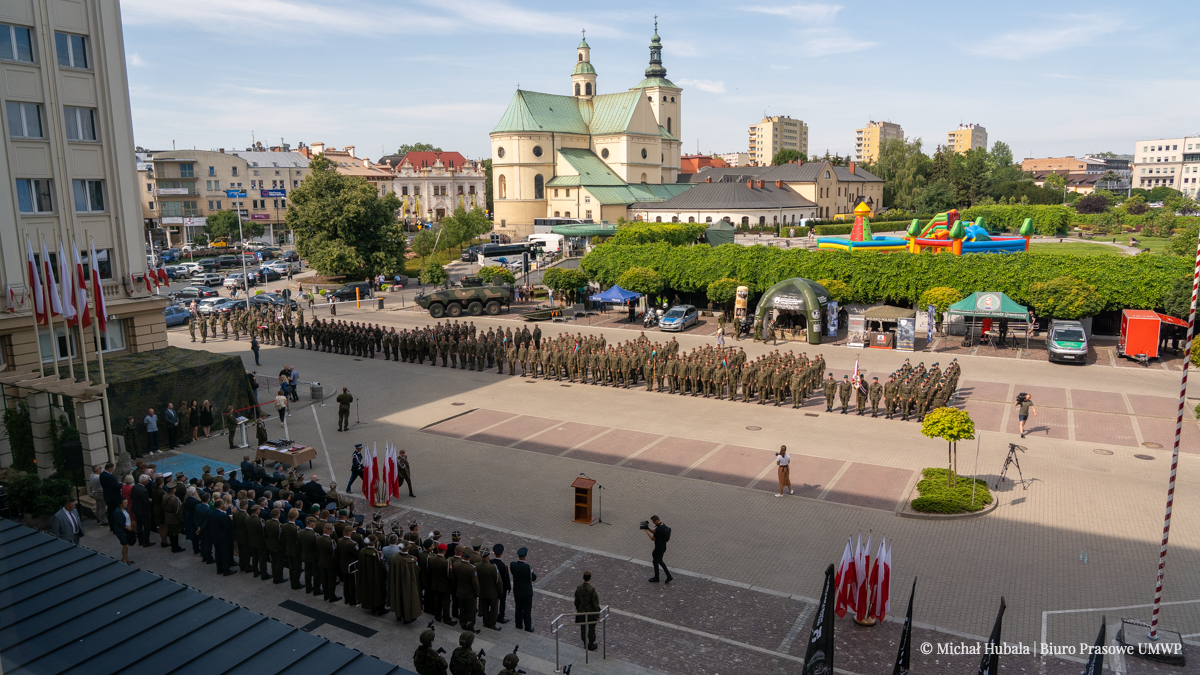 Żołnierze stojący w szeregach na dużym placu.